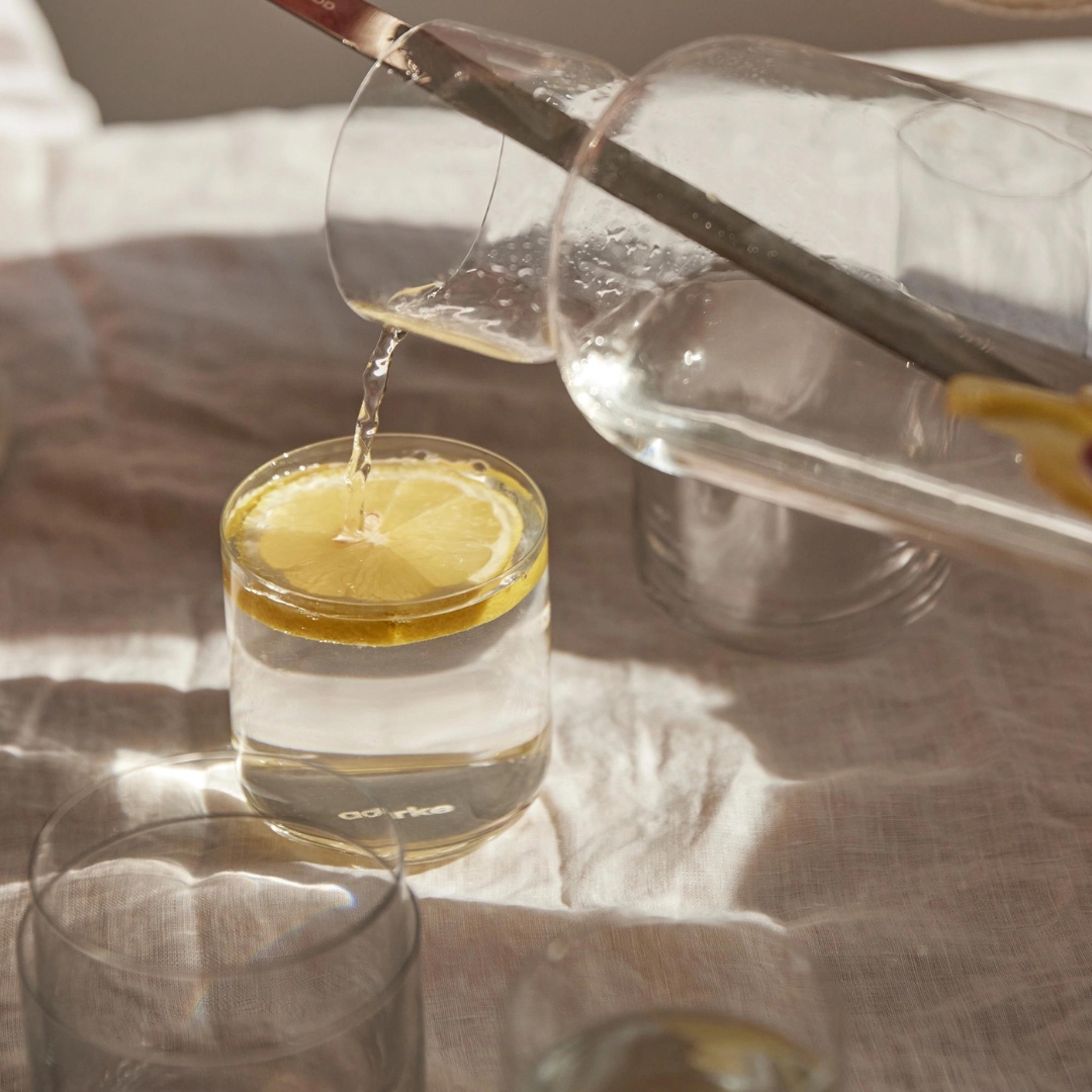 carafe en cristal aarke remplissant un verre en cristal aarke